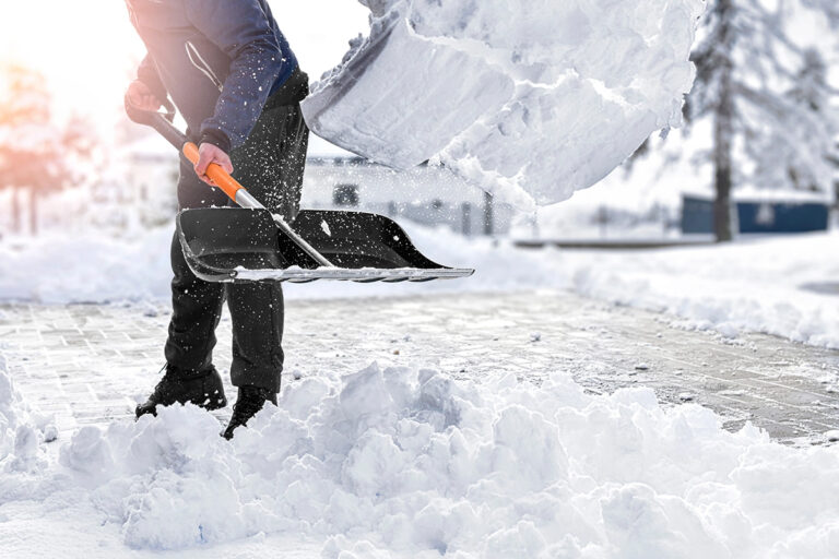 A man shovels snow off of a driveway. Northway Landscaping is committed to keeping your property free from snowdrifts this season.